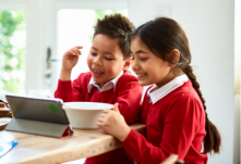 Children smile while watching tablet